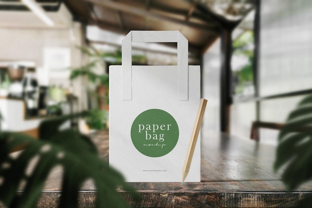 Clean Minimal Paper Bag Mockup on Wooden Surface with Leaves Background – Free Download