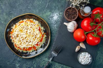 Top View of Mimosa Salad with Seasonings and Red Tomatoes on a Dark Blue Background – Free Download