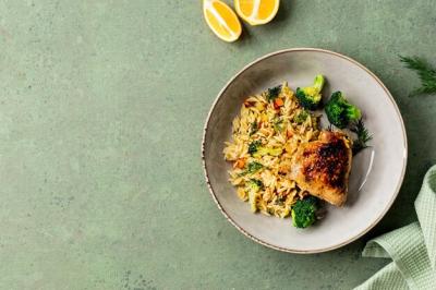 Bowl of Chicken Pasta Orzo with Vegetables on a Green Background – Free Download