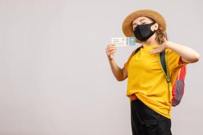 Young Woman with Backpack and Black Mask Holding Travel Ticket – Free Download