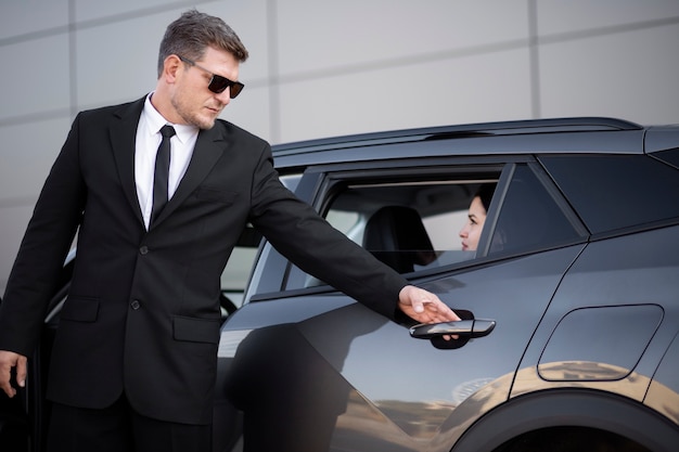 Young Male Uber Driver Assisting Female Passenger – Free Stock Photo, Download for Free