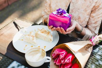 Young Stylish Woman Sitting in Cafe Holding Present Box – Free to Download