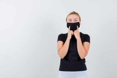 Cheerful Young Woman in Black T-Shirt with Medical Mask – Free to Download