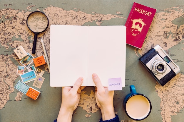 Person Holding Notepad Over Table with Map – Free to Download