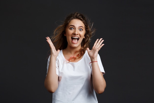 Young Beautiful Girl Smiling Joyfully Against a Grey Wall – Free Stock Photo for Download