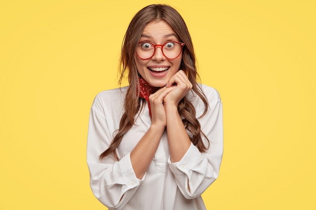 Happy Lady in Oversized White Shirt Expressing Joy on Yellow Background – Free Stock Photo, Download for Free