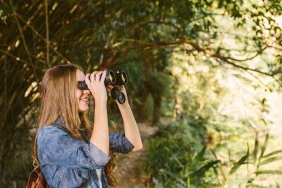 Smiling Young Woman Using Binoculars in the Forest – Free Stock Photo, Download for Free