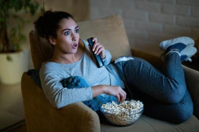 Young Woman in Disbelief Watching TV and Eating Popcorn at Home – Free Stock Photo, Download Free