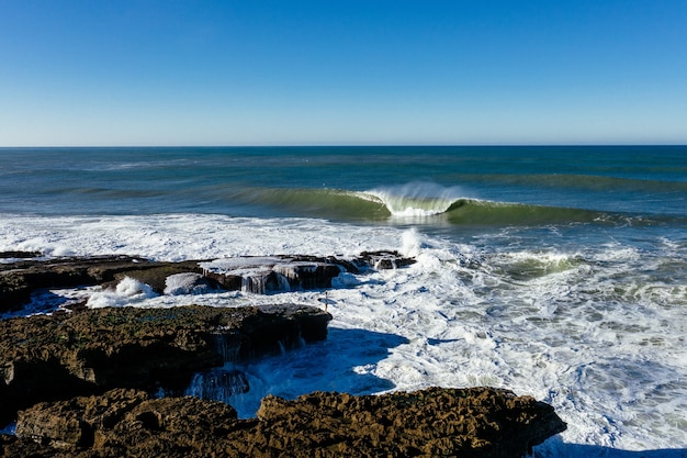 Foam Waves Crashing on Rocky Seashore – Free Download