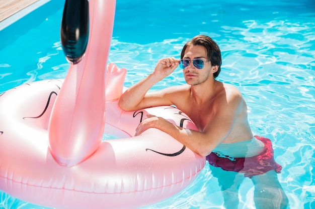 Man Posing on Flamingo Swim Ring – Free Download