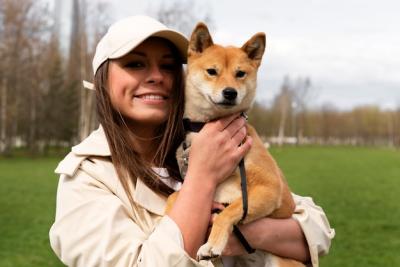 Smiley Woman Holding Cute Dog – Free Stock Photo for Download