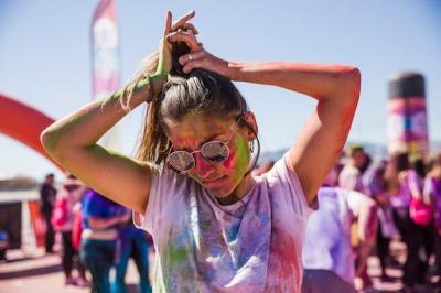 Young Woman with Holi Colors Fashionably Tying Her Hair Outdoors – Free Download