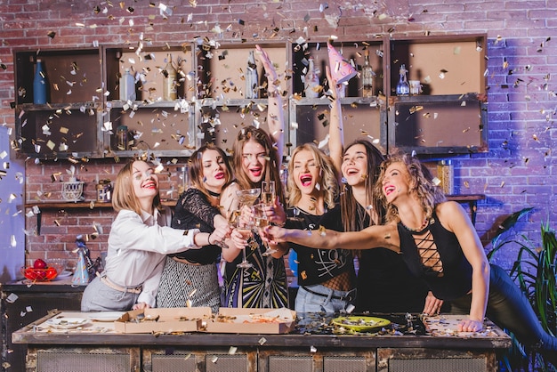 Pretty Women Clinking Glasses Surrounded by Confetti – Free Download