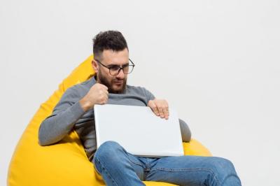 Frustrated Guy Sitting on a Yellow Pouf Chair – Free Download