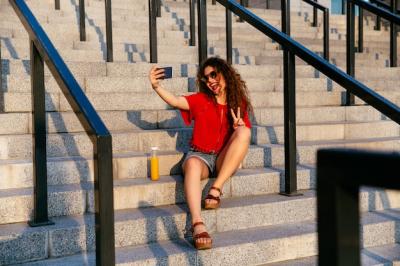 Cheerful Young Woman Making a Peace Gesture in a Selfie – Free Download