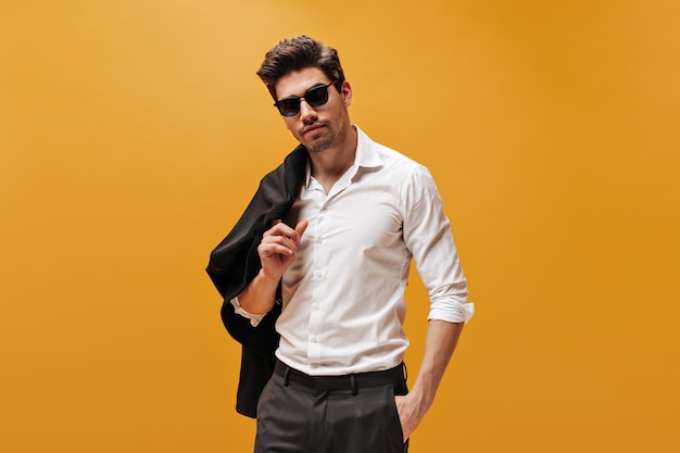 Brunet Man in Stylish White Shirt and Trendy Sunglasses on Orange Background – Free Download