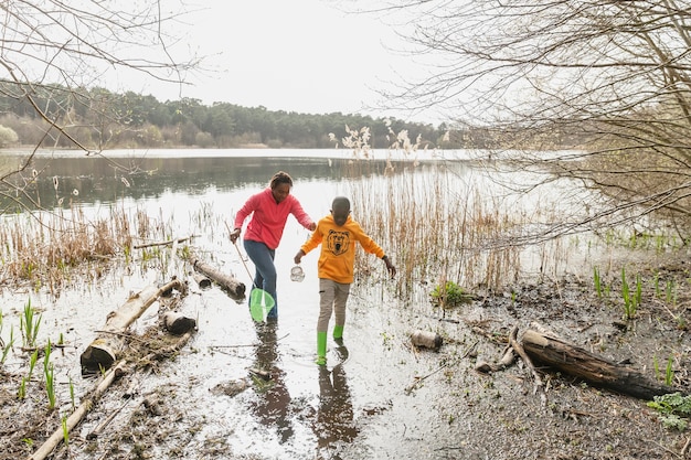 Mother and Son Enjoying a Muddy Adventure – Free Download