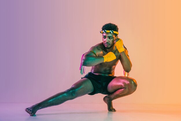 Young Man Practicing Muay Thai in Neon Light – Free Download