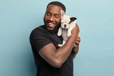 African American Man in Black T-Shirt Holding a Small Dog – Free Stock Photo for Download