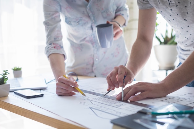 Hands Working on Blueprint Over Wooden Table – Free Stock Photo, Download Free