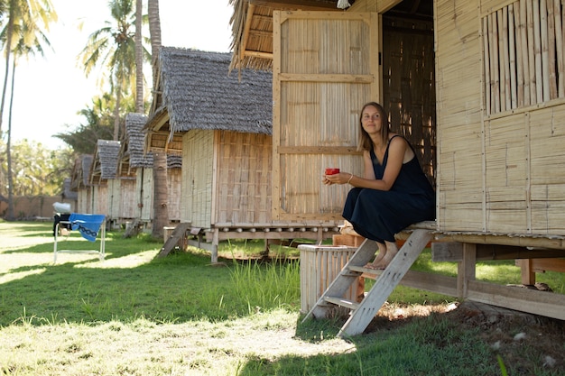 Beautiful Girl Enjoying Coffee by the Bungalow – Free Stock Photo, Download Free