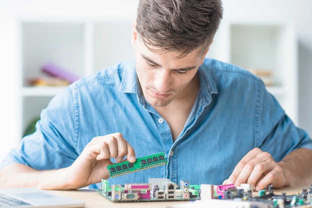 Young Male Technician Repairing RAM on Motherboard – Free Download