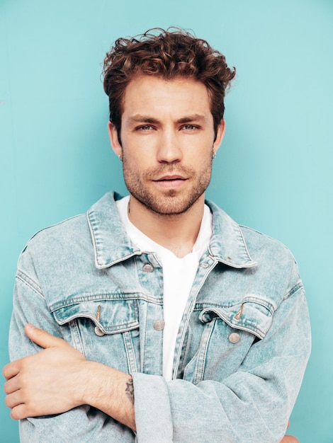 Handsome Confident Hipster Male in Jeans Jacket Against Blue Wall – Free Stock Photo for Download