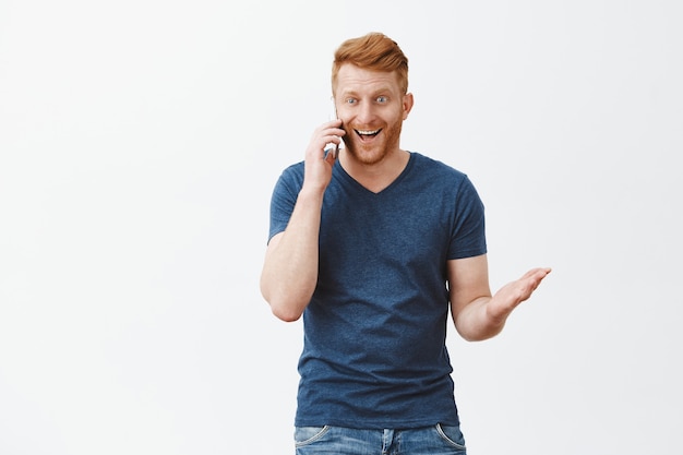 Handsome Excited Redhead Guy Smiling While Talking on Smartphone – Free Download