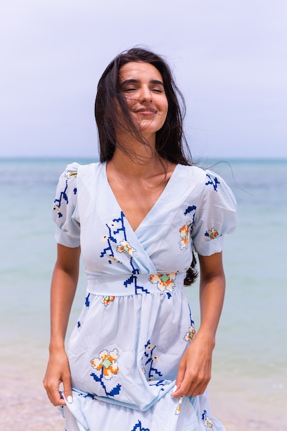 Romantic Portrait of a Woman in a Long Blue Dress on the Beach at Sea – Free to Download