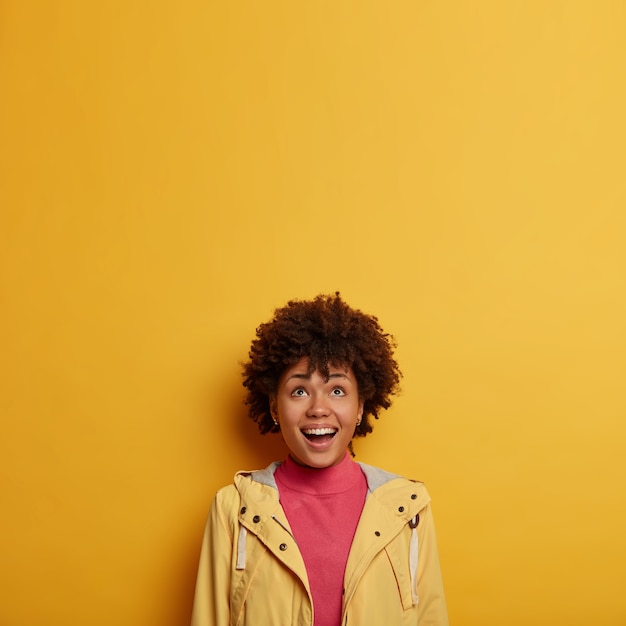 Happy Laughing Woman in Casual Jacket with Curly Hair Enjoying a Fun Advertisement – Free Download