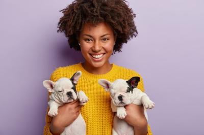 African American Woman in Yellow Sweater Holding Adorable Puppies – Free to Download