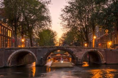 Stunning Netherlands Pink Sunset Over Amsterdam Canal with Pleasure Boat and Stone Bridge – Free Download