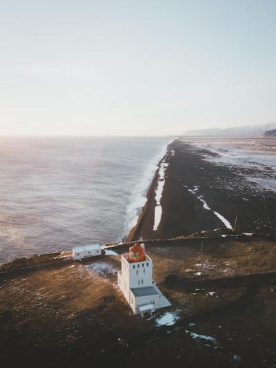 High Angle View of a Lighthouse by the Sea Against a Clear Sky – Free Stock Photo for Download