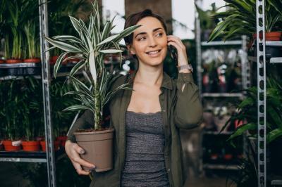 Female Gardener in Plant House Surrounded by Plants and Flowers – Free to Download