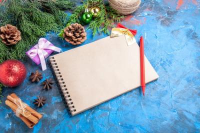 Notebook, Pine Tree Branches, Red Pencil, and Pinecones Against a Blue Background – Free Stock Photo, Download for Free