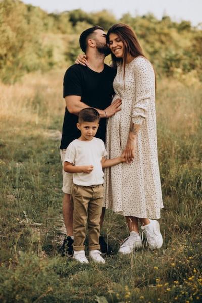 Young Pregnant Woman with Husband and Son in a Forest – Free Download