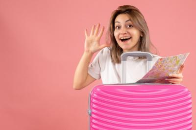 Young Girl with Pink Suitcase Holding Map and Waving Hand – Free Stock Photo for Download