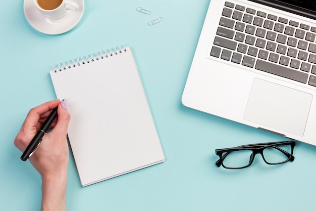 A Businesswoman Writing on a Spiral Notepad at the Office Desk – Free Stock Photo, Download Free