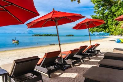 Stunning Tropical Beach Scene with Umbrella Chairs and Deck under Blue Sky – Free Download