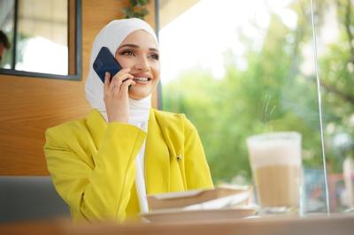 Young Muslim Businesswoman in Headscarf at Cafe Talking on Phone – Free Download