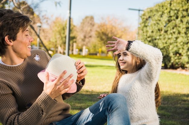 Father and Daughter Playing with Hat in Park – Free to Download