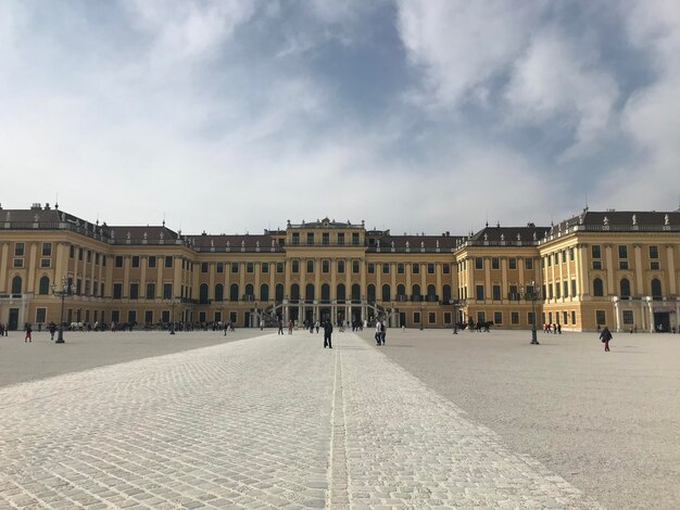 A Large Yellow Building with an Impressive Entrance and People Walking – Free Download