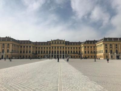 A Large Yellow Building with an Impressive Entrance and People Walking – Free Download