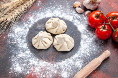 Close-Up View of Khinkali Flour, Tomatoes, and Garlic with Rolling Pin – Free Download
