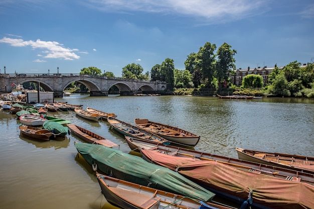 Small Wooden Boats on the Thames River Near an Old Bridge – Free Download