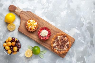 Different Creamy and Fruity Cakes with Lemon and Cherries on Light Desk – Free Download