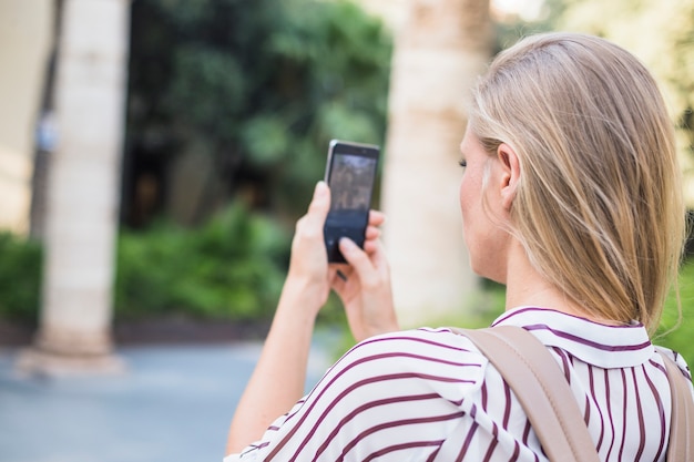 Blonde Young Woman Taking Photograph on Mobile Phone – Free Download
