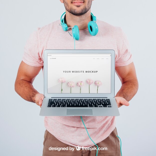 Young Guy Holding Laptop Mockup – Free Download