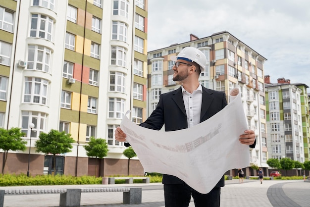 Man in Hardhat Reviewing Architectural Construction Drawings – Free Download