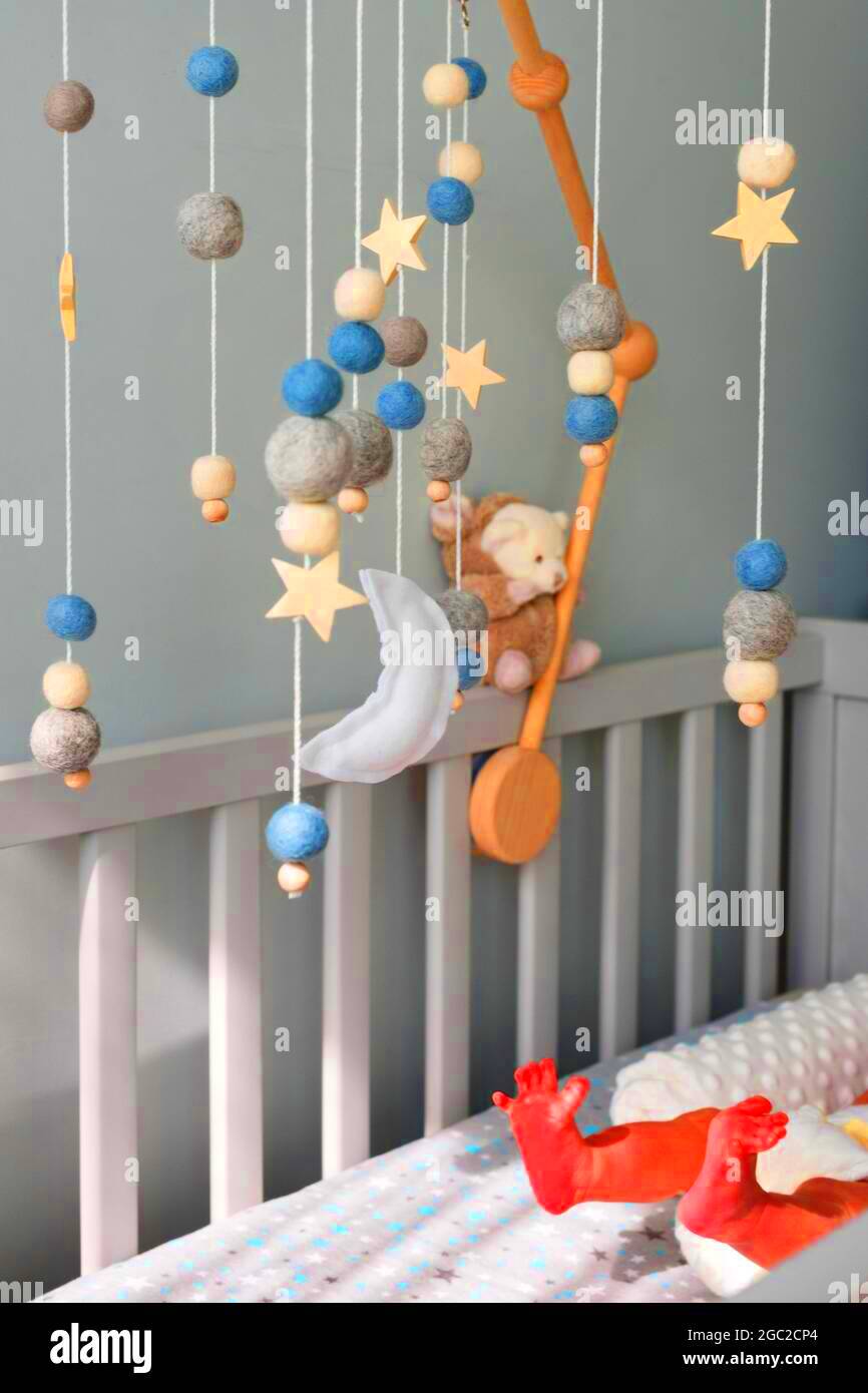 Baby crib mobile with stars planets and moon hang over the sleeping 